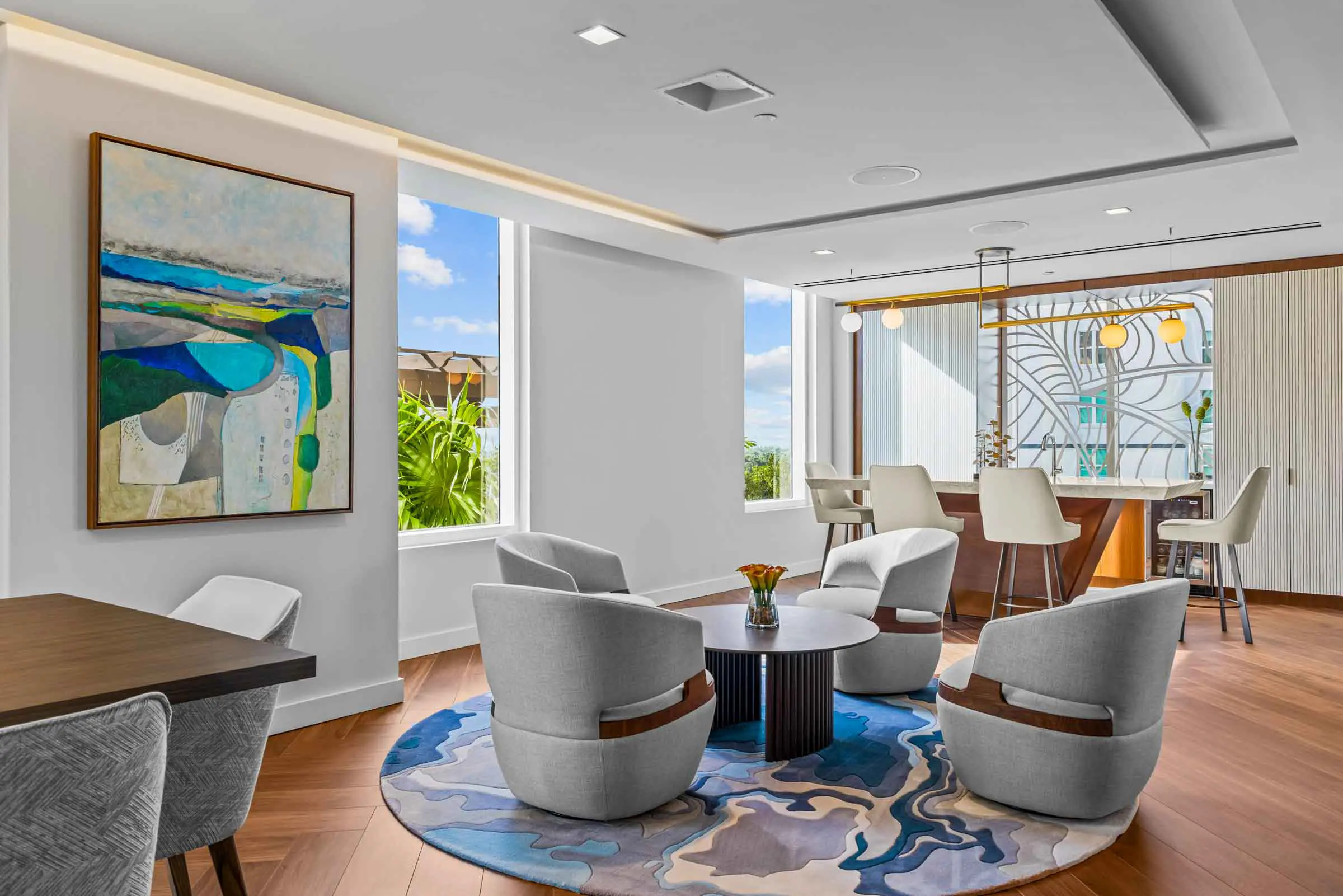 Modern living room with stylish furniture and large windows.