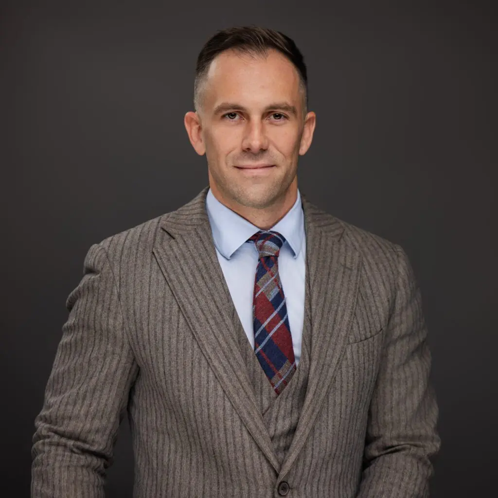 Professional man in a striped suit and tie, posing confidently.
