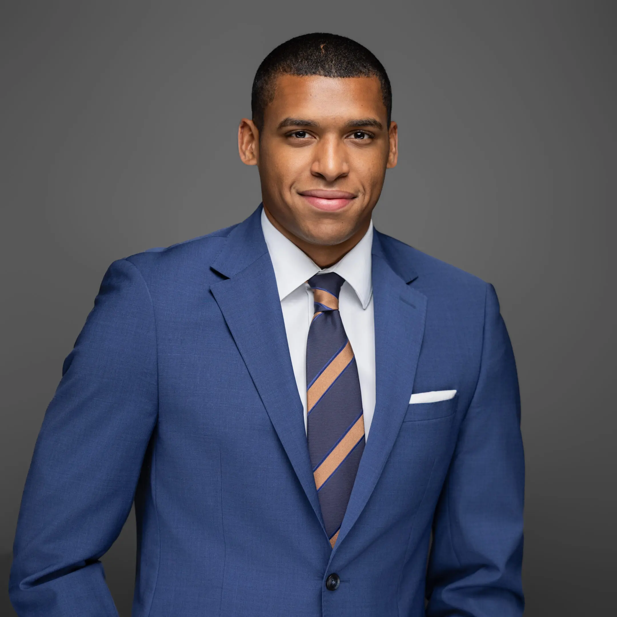 Confident man in a blue suit and striped tie.